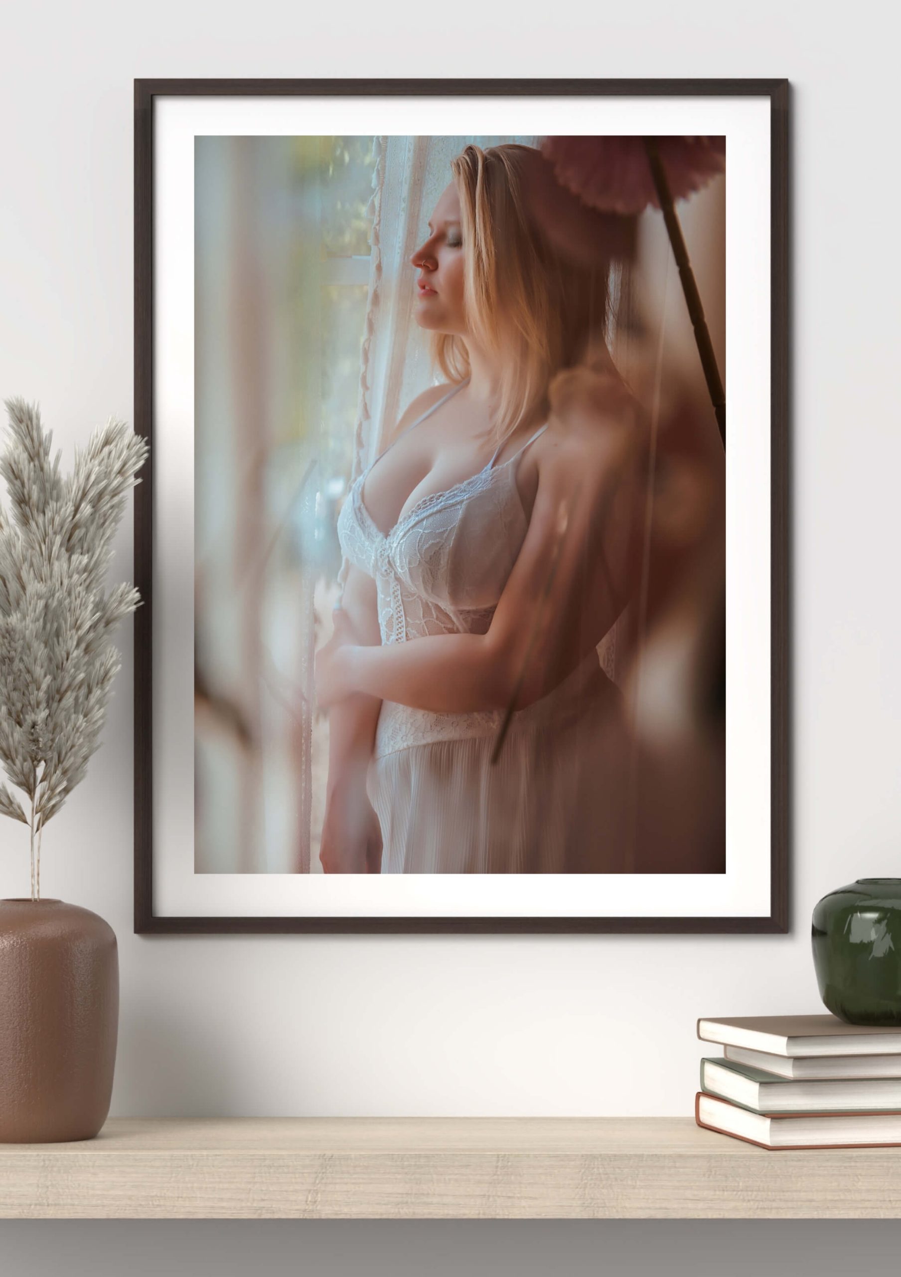 Framed boudoir print featuring a woman gazing out a window.