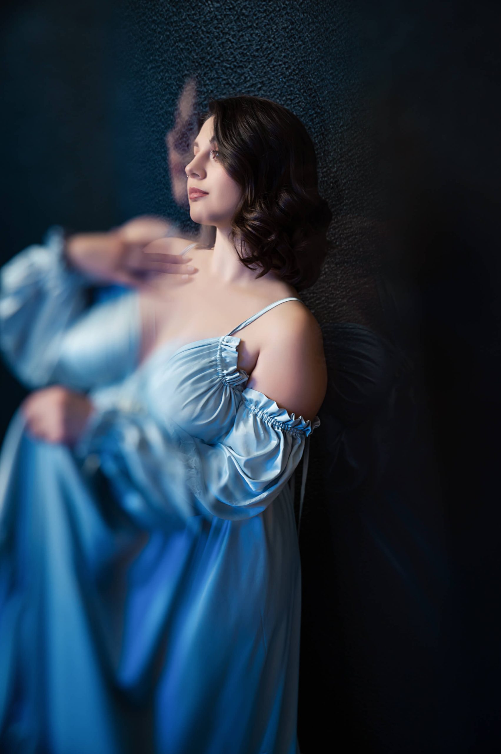 Woman twirling in large blue gown during boudoir shoot