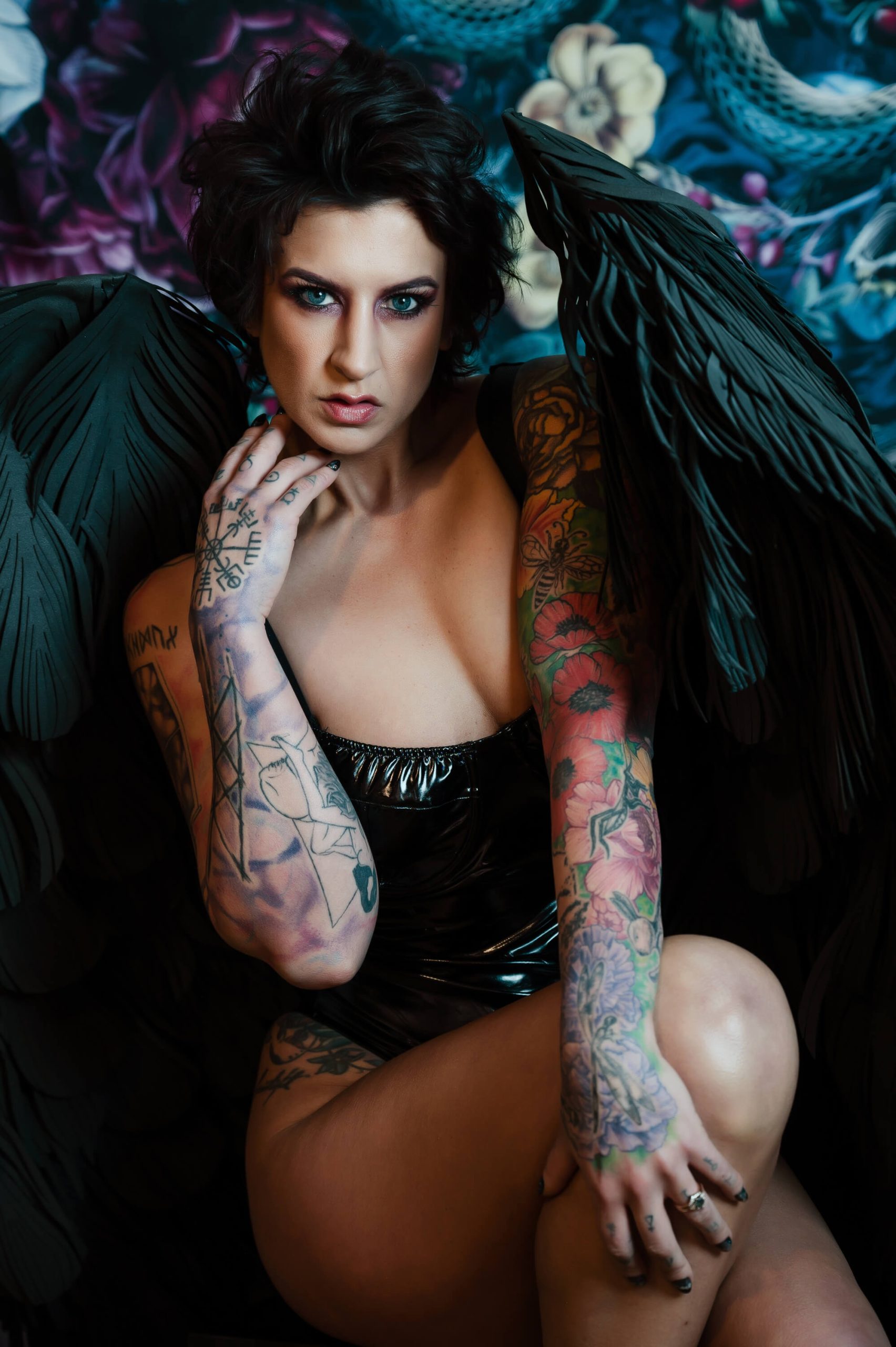 Woman with Tattoos Wearing Black Wings and a Fierce Expression
